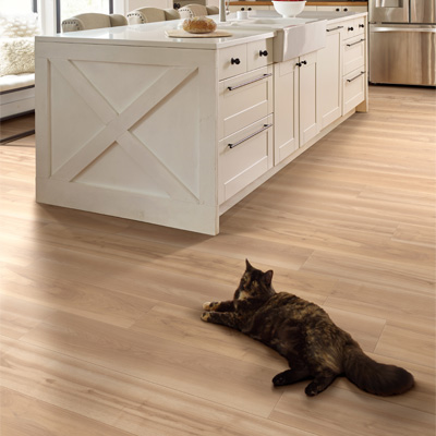 cat laying on luxury vinyl plank flooring in kitchen.